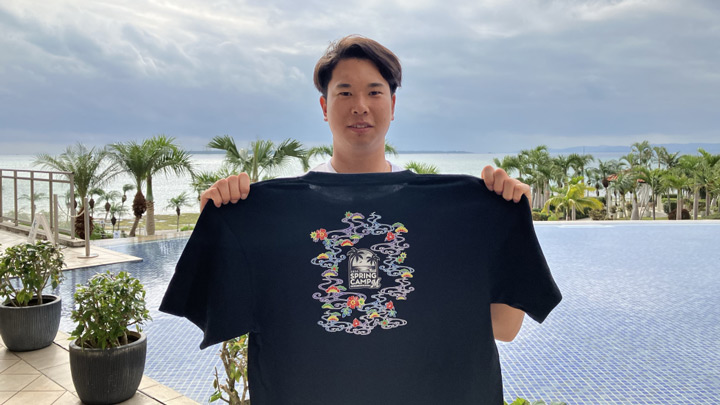 2024年 春季キャンプ限定グッズのTシャツを持つ上田希由翔選手【写真：球団提供】